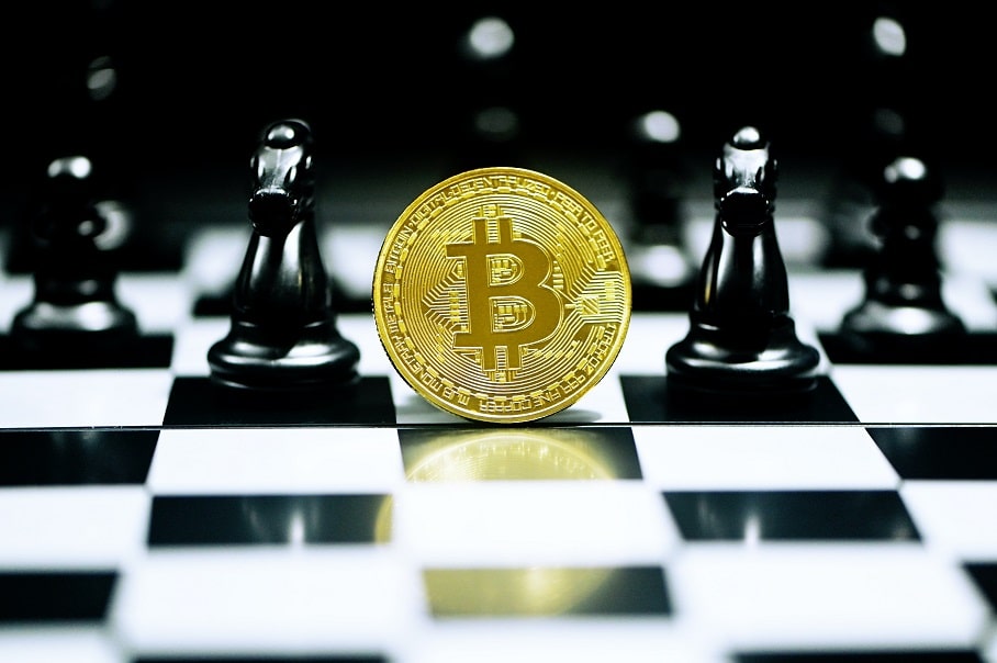 A coin with a bitcoin logo on the chessboard.